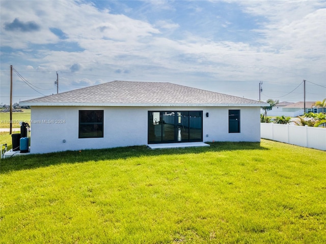 rear view of property featuring a lawn