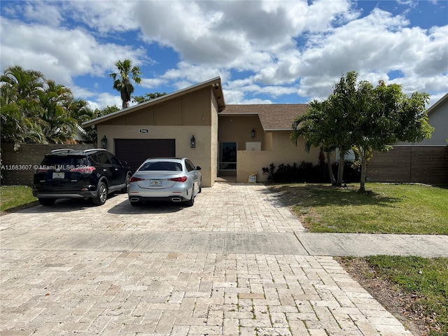 ranch-style home featuring a garage and a front lawn