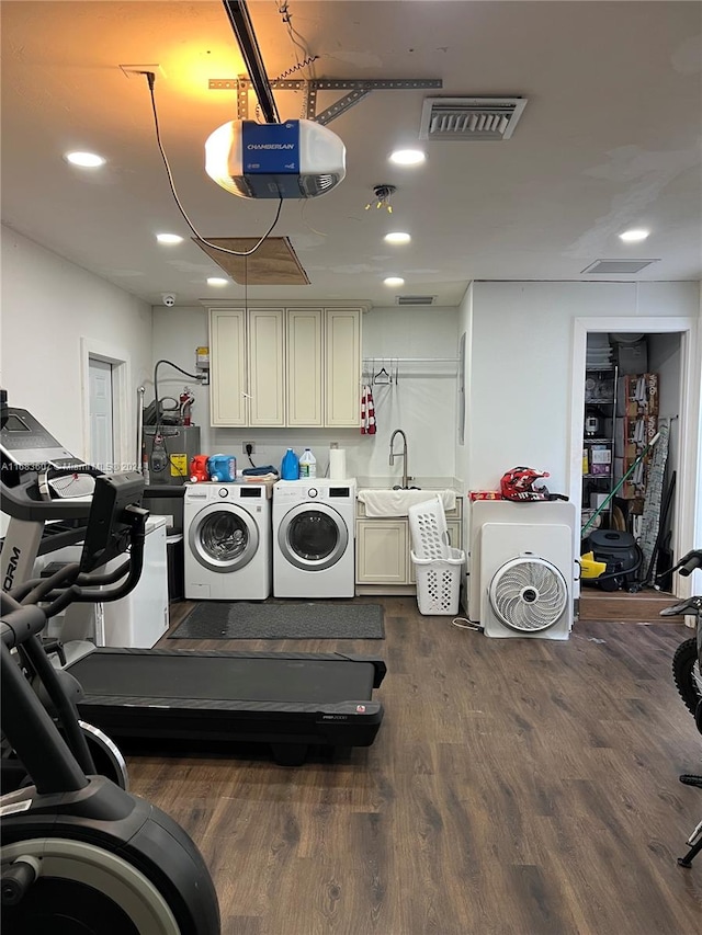 laundry room with cabinets, dark hardwood / wood-style flooring, washer and clothes dryer, and sink