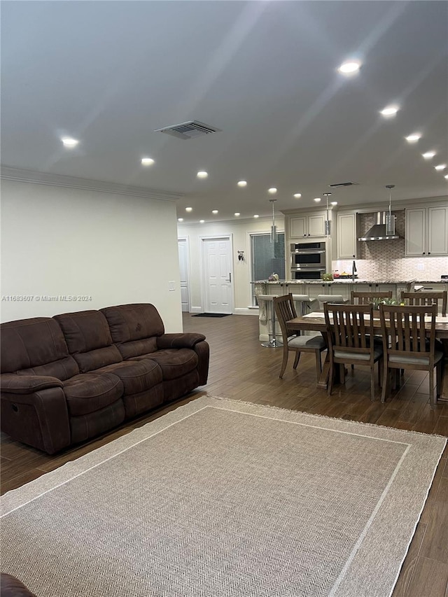 living room featuring dark hardwood / wood-style floors and crown molding