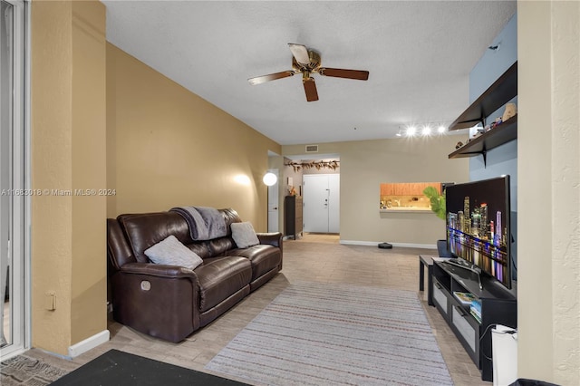 living room featuring a textured ceiling and ceiling fan