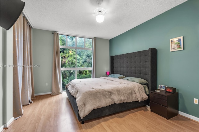 bedroom featuring expansive windows, a textured ceiling, and light wood-type flooring