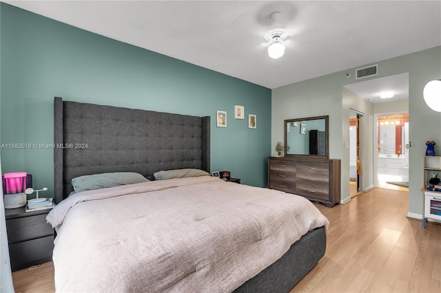 bedroom featuring connected bathroom, ceiling fan, a textured ceiling, and light hardwood / wood-style flooring