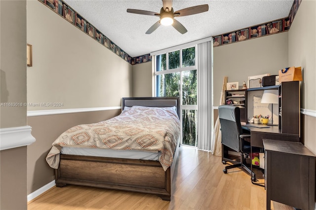 bedroom featuring a textured ceiling, light wood-type flooring, and ceiling fan