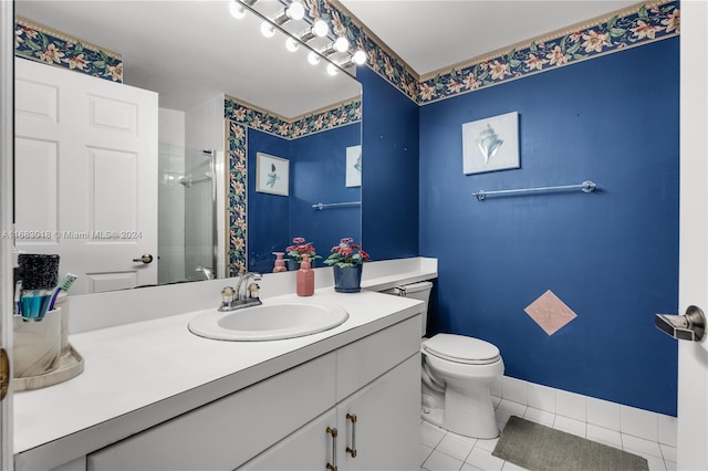 bathroom with vanity, toilet, tile patterned floors, and tiled shower