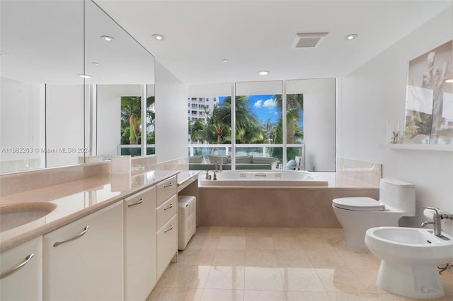 bathroom with vanity, toilet, a bidet, and a washtub