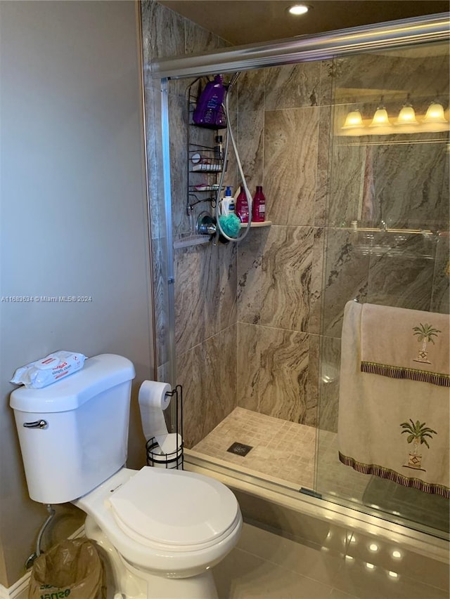 bathroom featuring toilet, an enclosed shower, and tile patterned flooring