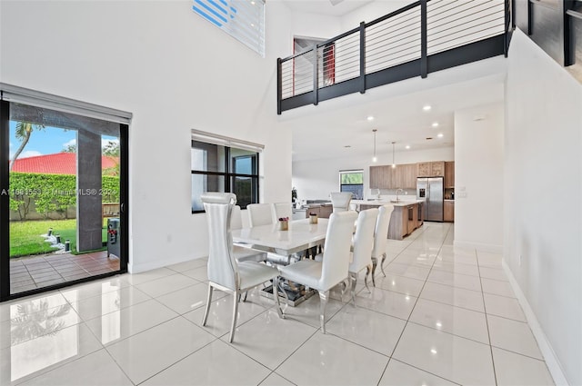 tiled dining area featuring sink and a high ceiling