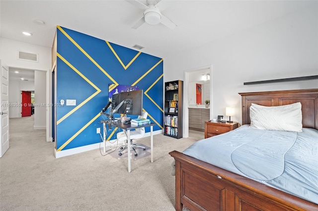 bedroom with ensuite bath, light colored carpet, and ceiling fan