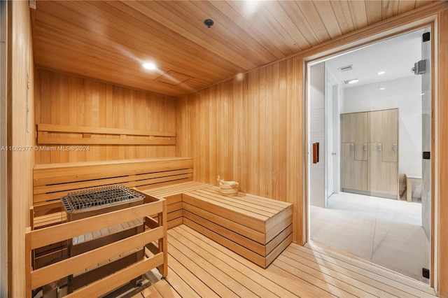 view of sauna featuring wooden ceiling, wooden walls, and hardwood / wood-style floors