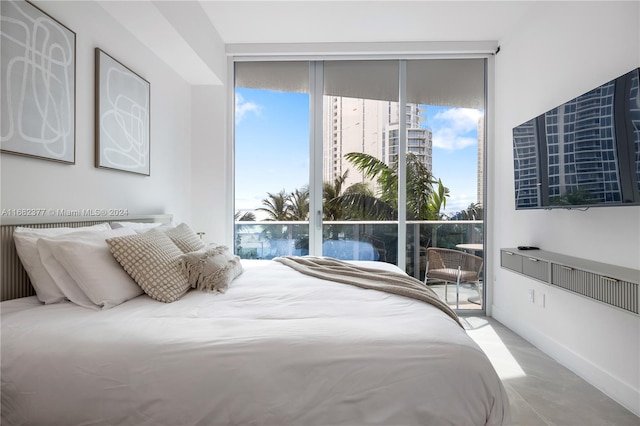 bedroom with concrete floors and access to outside