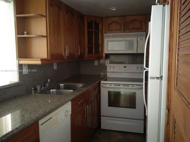 kitchen with white appliances, light stone counters, decorative backsplash, and sink