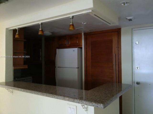 kitchen featuring kitchen peninsula and white fridge