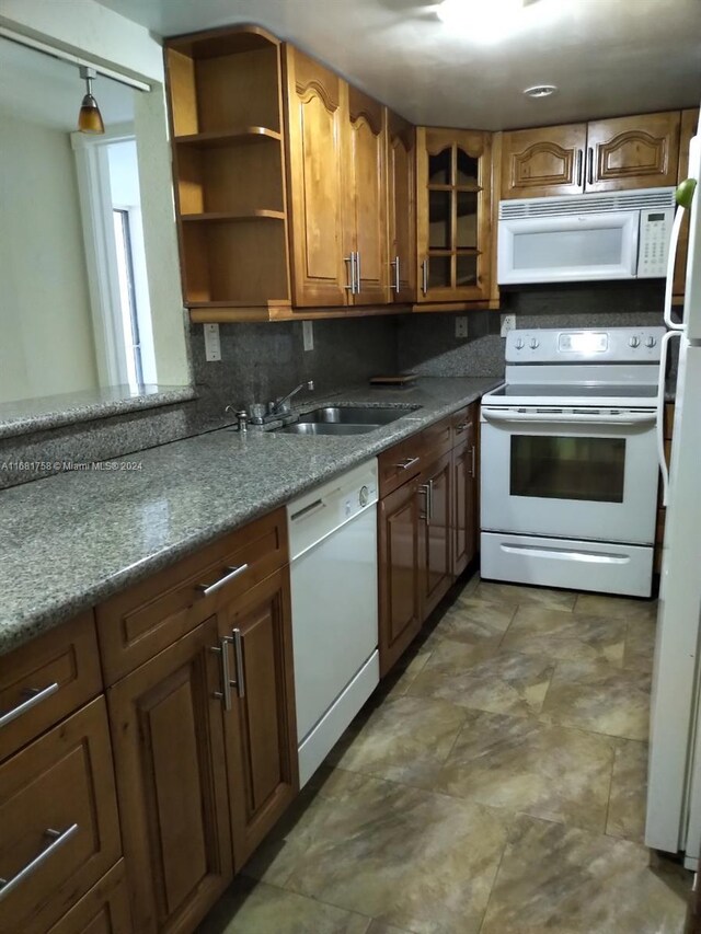 kitchen with sink, white appliances, and tasteful backsplash