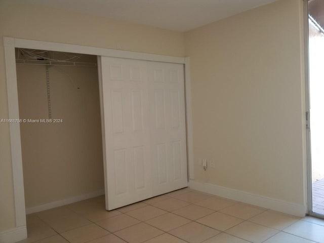 unfurnished bedroom featuring a closet and light tile patterned flooring