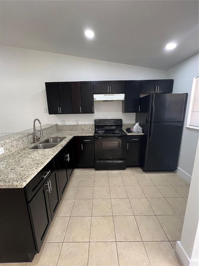 kitchen with lofted ceiling, light stone counters, light tile patterned floors, black appliances, and sink