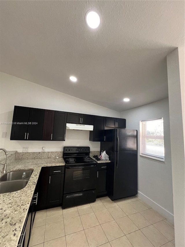 kitchen featuring light stone countertops, black appliances, sink, vaulted ceiling, and light tile patterned floors