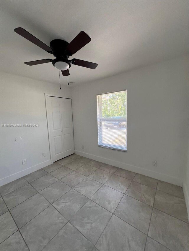 spare room featuring light tile patterned flooring and ceiling fan