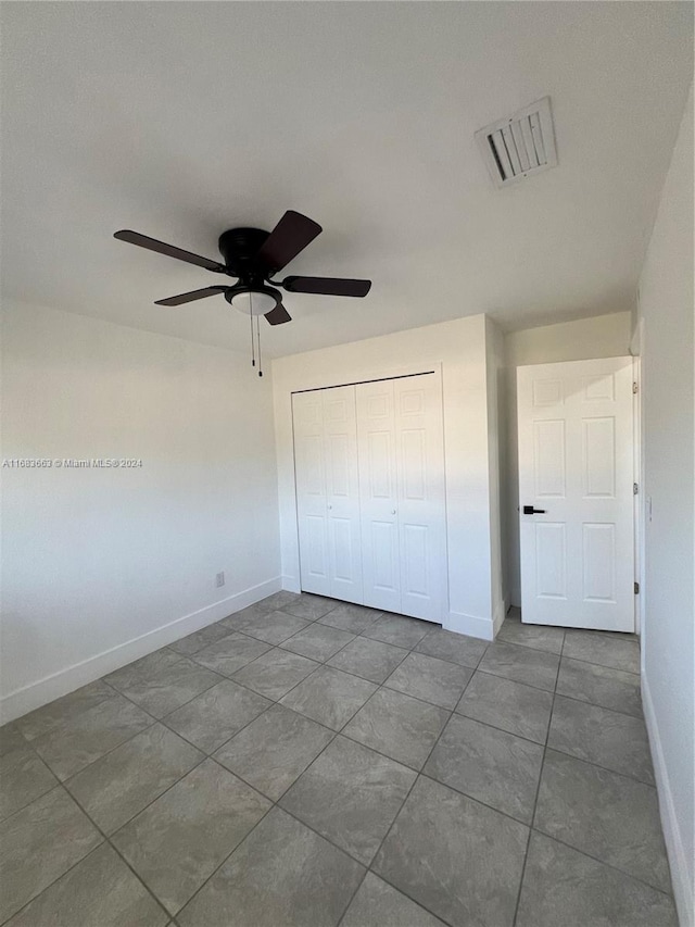 unfurnished bedroom with a closet, tile patterned flooring, and ceiling fan