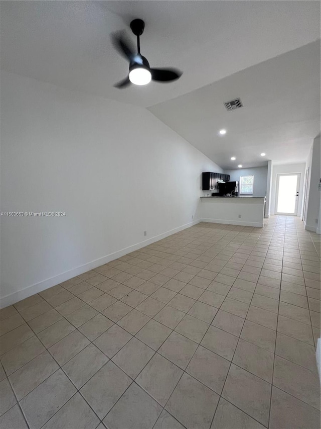 unfurnished living room featuring ceiling fan, lofted ceiling, and light tile patterned floors