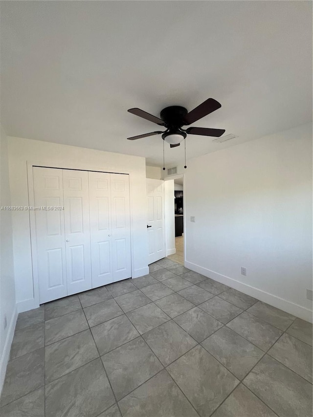 unfurnished bedroom featuring light tile patterned floors, a closet, and ceiling fan