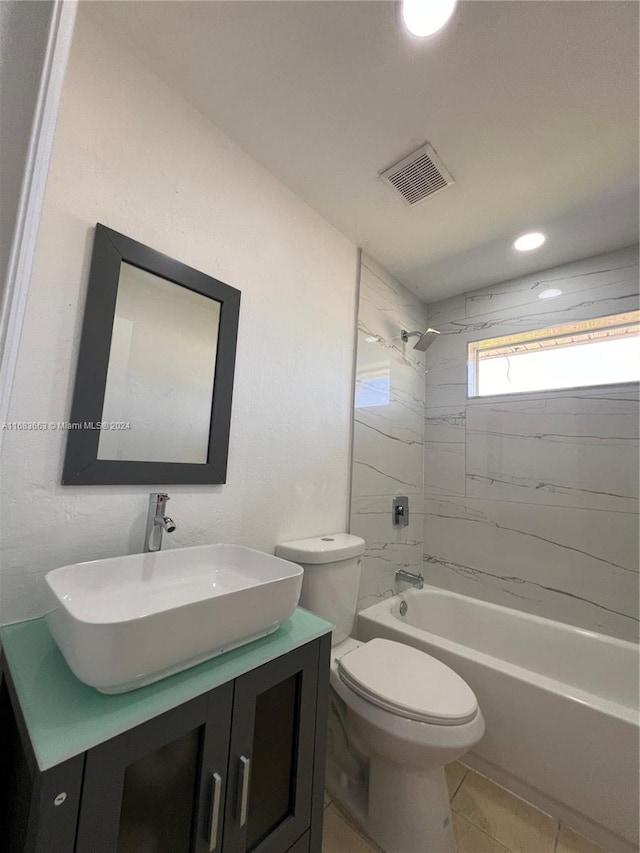 full bathroom with vanity, tiled shower / bath, toilet, and tile patterned flooring