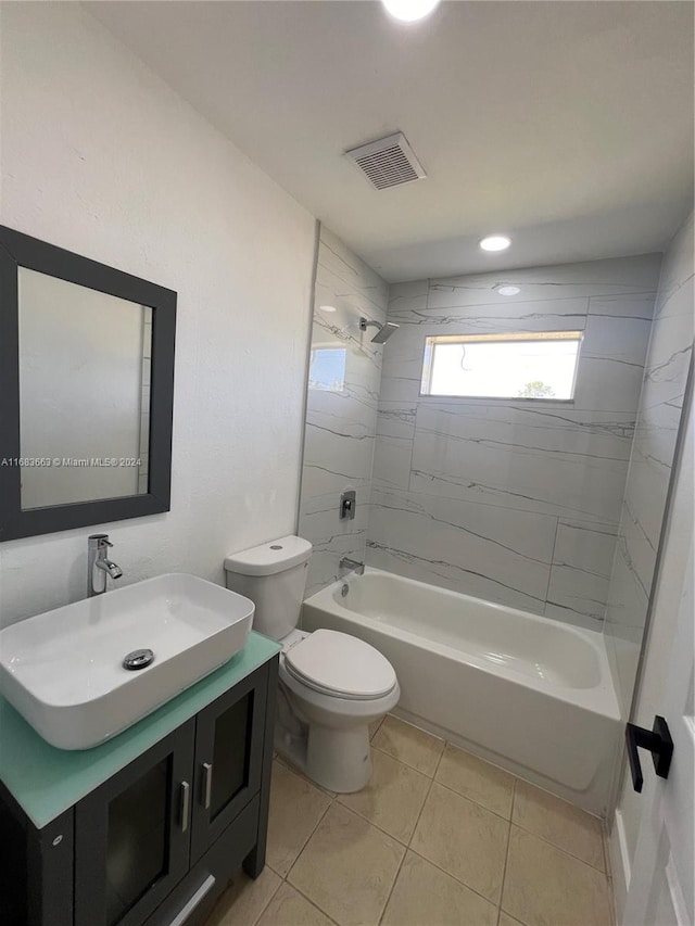 full bathroom featuring vanity, tiled shower / bath combo, toilet, and tile patterned flooring