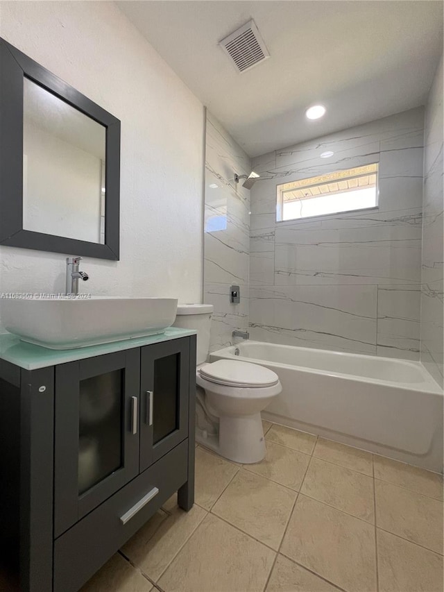 full bathroom featuring vanity, tiled shower / bath combo, toilet, and tile patterned flooring