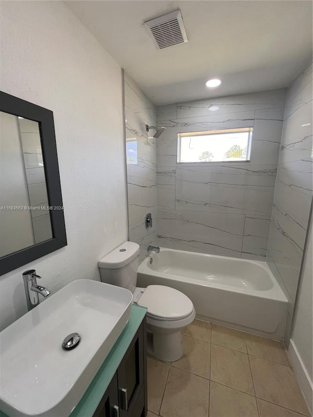 full bathroom featuring vanity, toilet, tile patterned floors, and tiled shower / bath combo