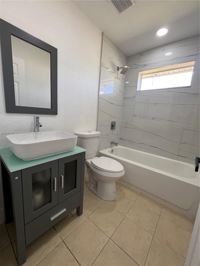 full bathroom featuring vanity, tiled shower / bath combo, toilet, and tile patterned flooring