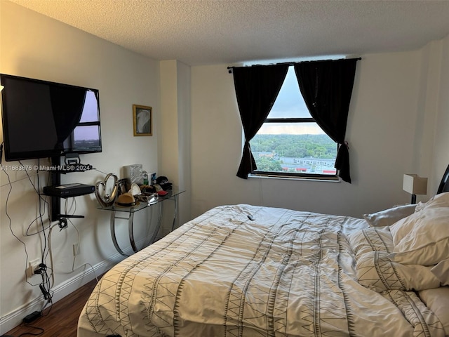 bedroom with a textured ceiling and hardwood / wood-style floors