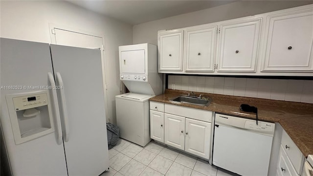 washroom with stacked washer / drying machine, sink, and light tile patterned floors