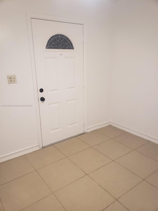 entryway featuring baseboards and light tile patterned flooring