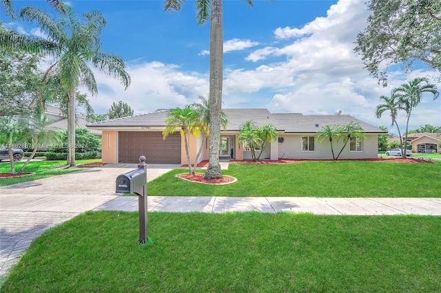 single story home with a garage and a front lawn