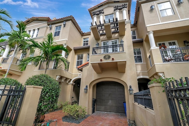 townhome / multi-family property featuring a balcony and a garage