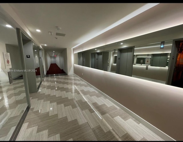 hallway featuring carpet and elevator