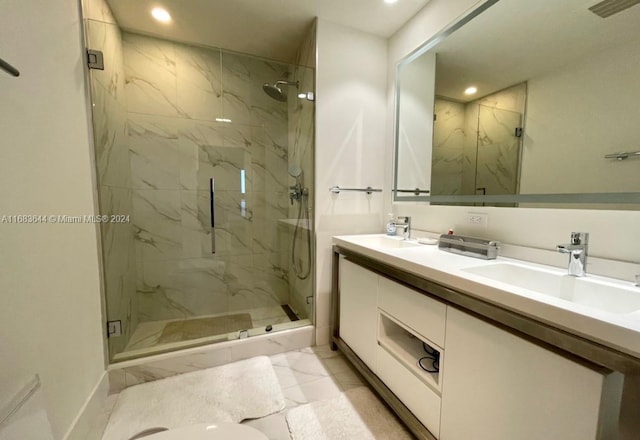 bathroom with a shower with door, vanity, and tile patterned floors