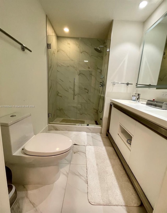 bathroom with toilet, vanity, and a shower with shower door