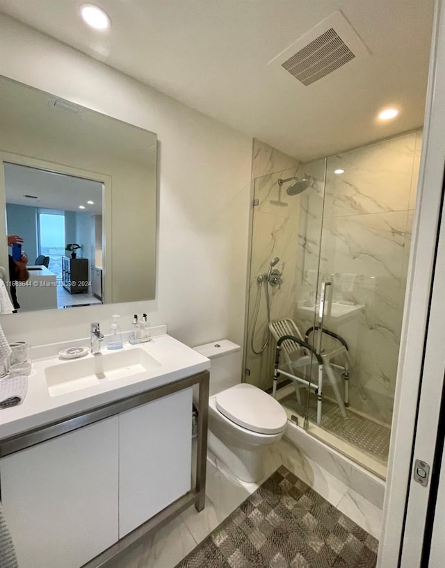 bathroom featuring toilet, a shower with door, and vanity