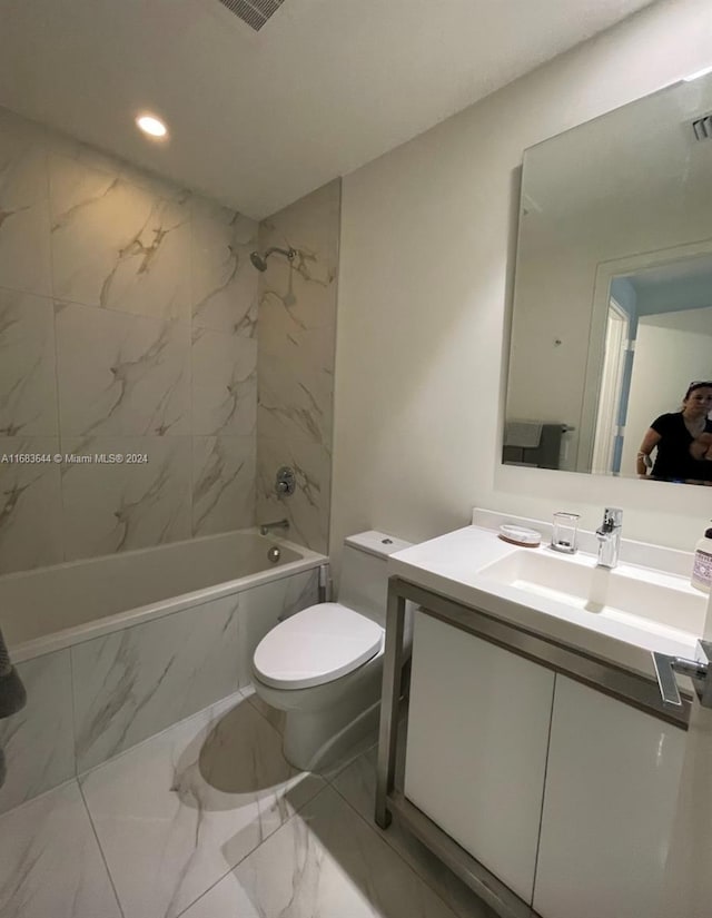 full bathroom featuring toilet, tiled shower / bath, and vanity