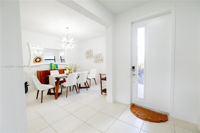 foyer featuring a notable chandelier, light tile patterned flooring, and a wealth of natural light