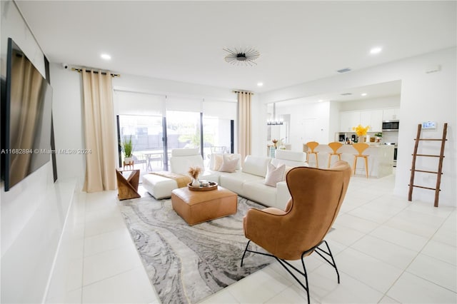 tiled living room with a notable chandelier