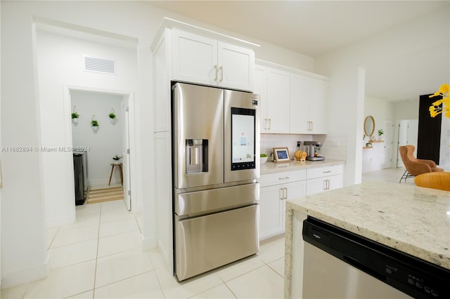 kitchen featuring white cabinetry, light stone counters, appliances with stainless steel finishes, and light tile patterned floors