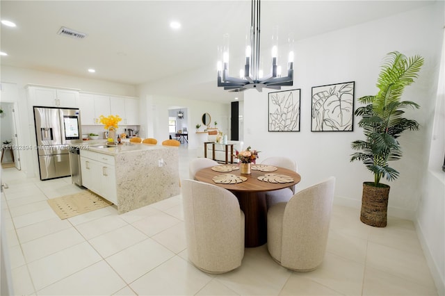 dining room with sink, a notable chandelier, and light tile patterned floors