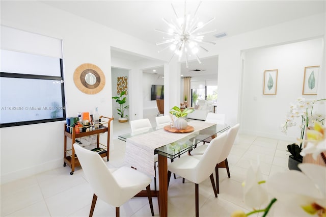 tiled dining room with a notable chandelier