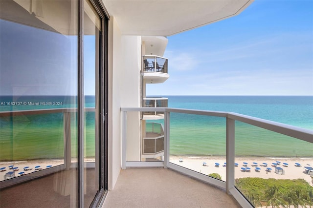 balcony with a water view and a beach view