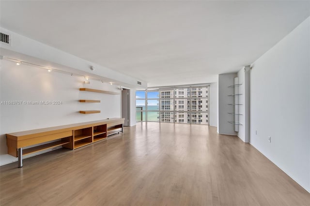 unfurnished living room with wood-type flooring and floor to ceiling windows