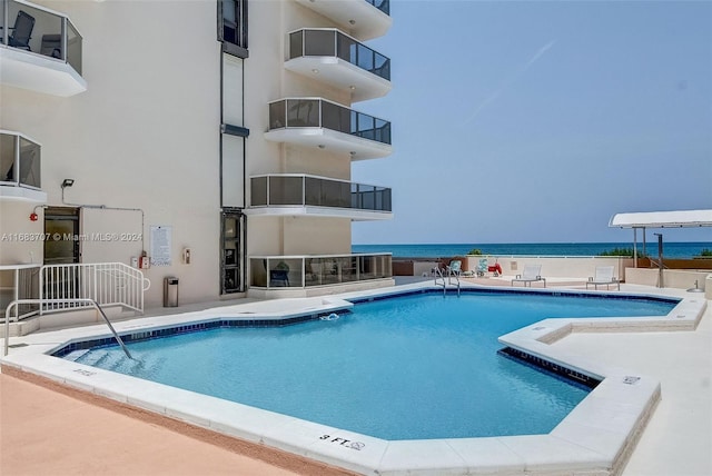 view of swimming pool featuring a patio area and a water view