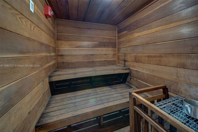 view of sauna featuring wood ceiling and wooden walls