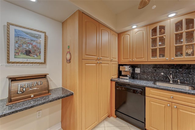 kitchen featuring black dishwasher, sink, dark stone counters, decorative backsplash, and light tile patterned floors